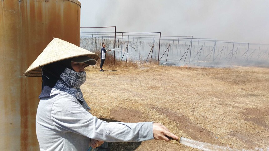 Women hose a fire.