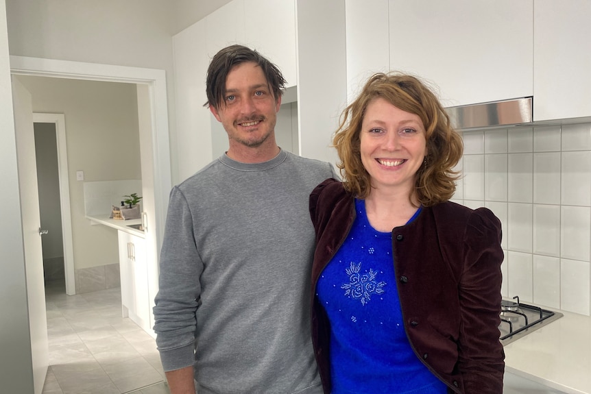 A man and a woman smiling in a kitchen