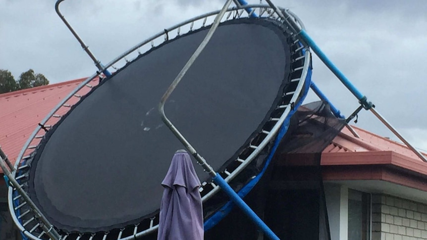A trampoline sits on top of the roof of a house