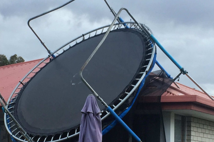 A trampoline sits on top of the roof of a house