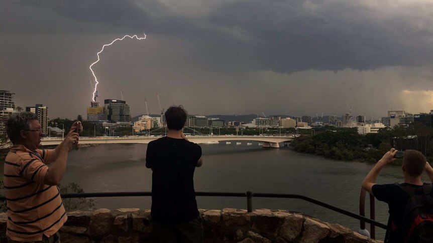 People at Kangaroo Point in Brisbane gather to watch a thunderstorm