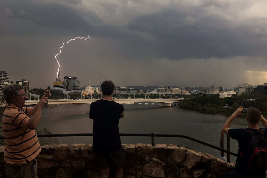 People at Kangaroo Point in Brisbane gather to watch a thunderstorm