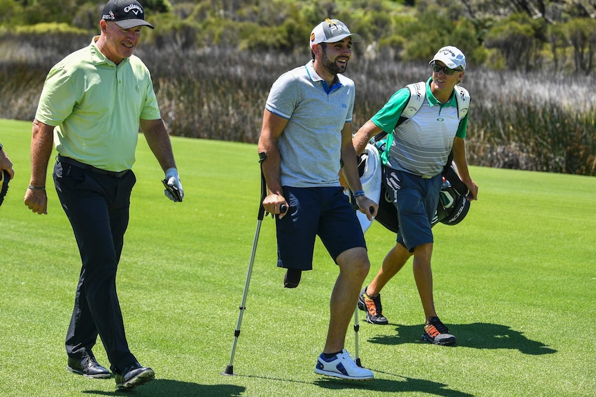 Juan Postigo walks with Australian golfer Peter Lonard during practice at the 2018 Emirates Australian Open in Sydney
