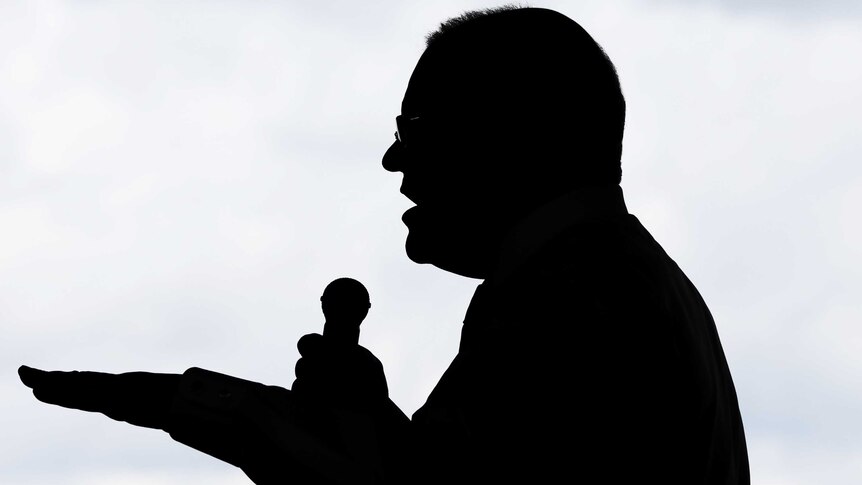 Prime Minister Scott Morrison is seen silhouetted while speaking into a microphone at an election campaign event in Brisbane.