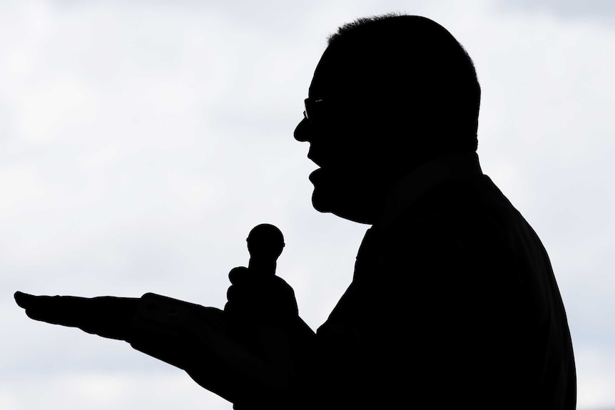 Prime Minister Scott Morrison is seen silhouetted while speaking into a microphone at an election campaign event in Brisbane.