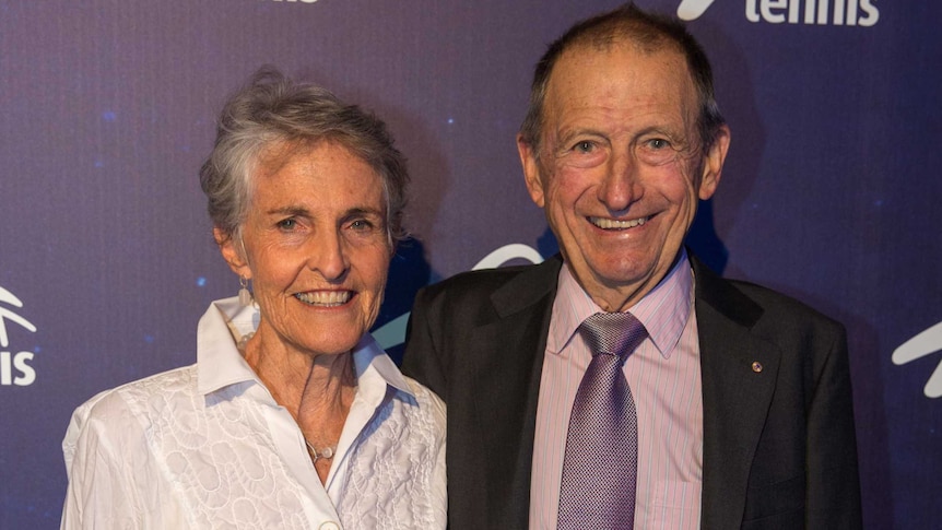 A male and a female smile as they pose for a photograph.