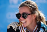 Australia's Britt Cox bites her gold medal at the 2017 Snowboarding and Freestyle Skiing World Cup.
