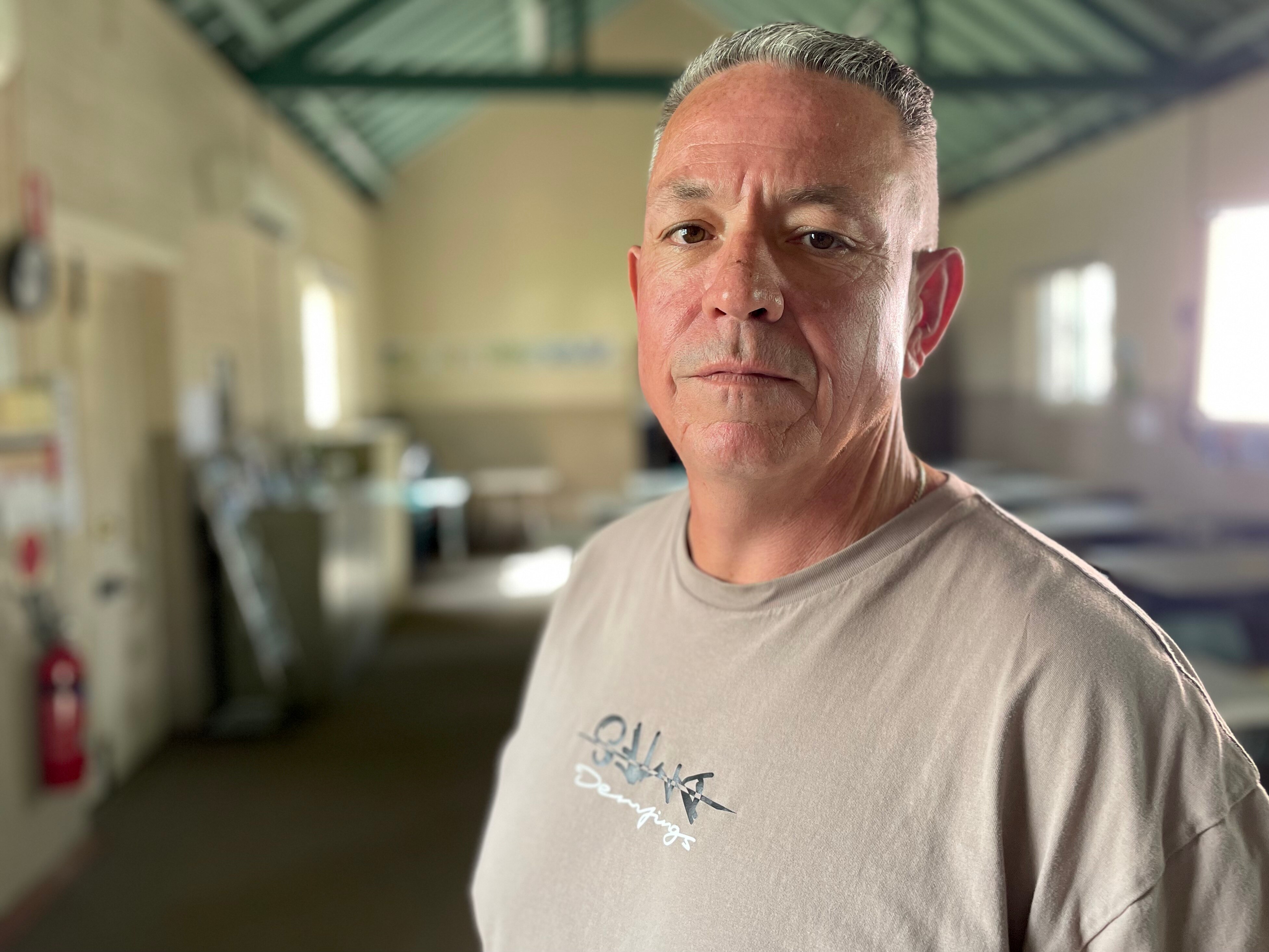 man stands in hall with neutral face