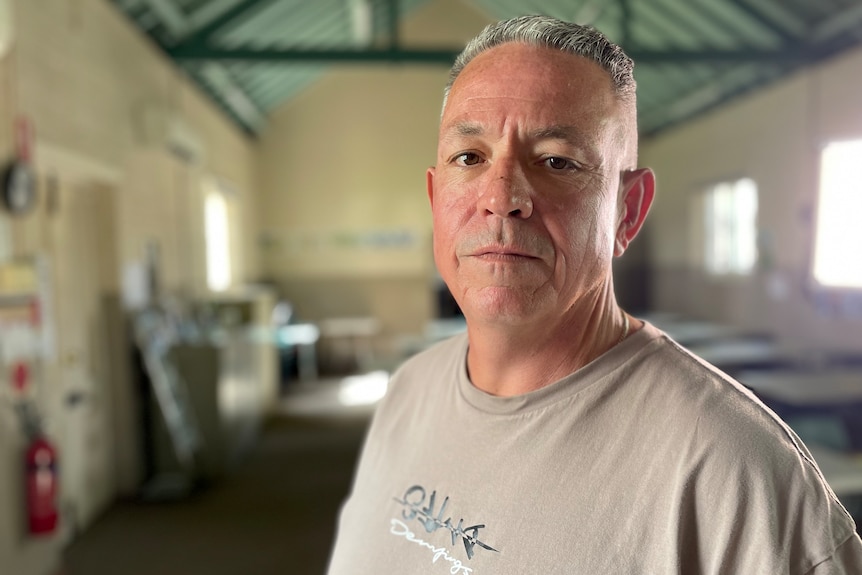 man stands in hall with neutral face