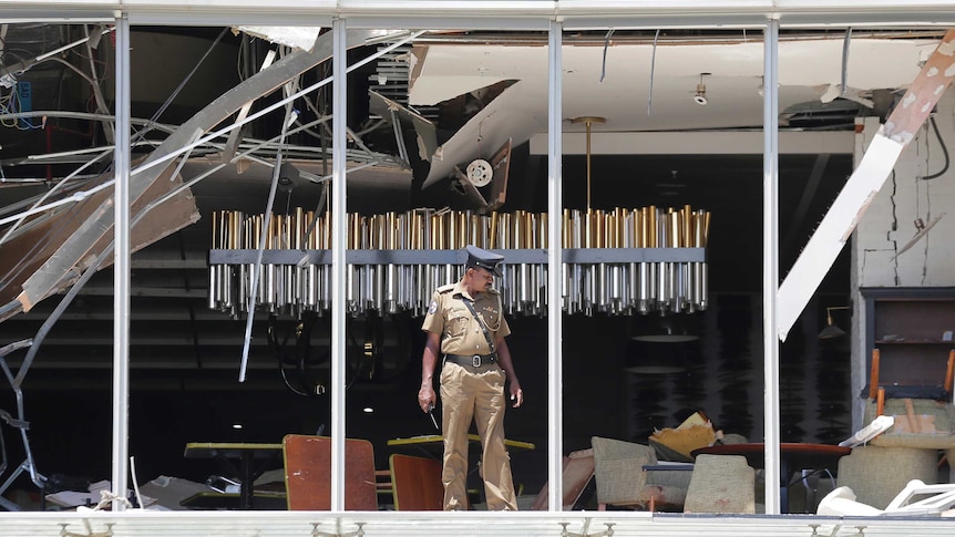 A Sri Lankan Police officer inspects a blast spot at the Shangri-la hotel in Colombo.