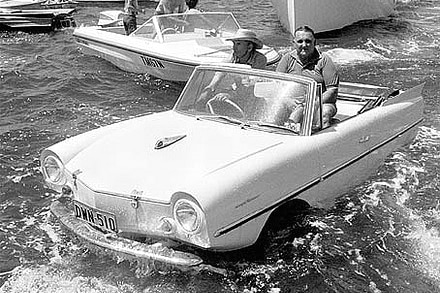 An amphibious car floating in the water in front of boats on Sydney Harbour.