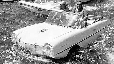 An amphibious car floating in the water in front of boats on Sydney Harbour.
