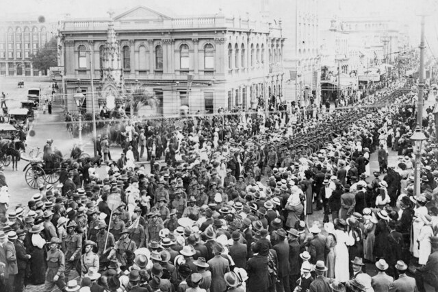 Black and white photograph of soldiers marching through Brisbane street