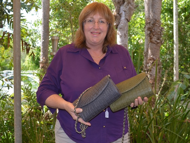 Angela Freeman holding two crocodile skin clutch purses