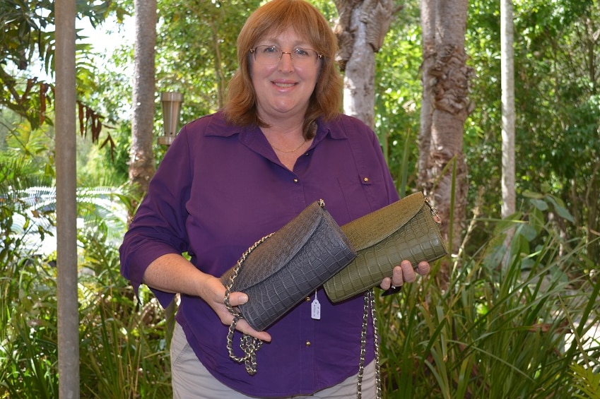 Angela Freeman holding two crocodile skin clutch purses