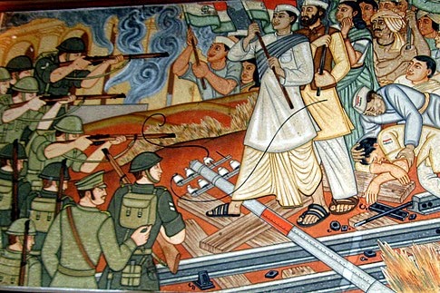 A mural showing men and women in traditional Indian clothing, holding the Indian flag, facing British armed soldiers.