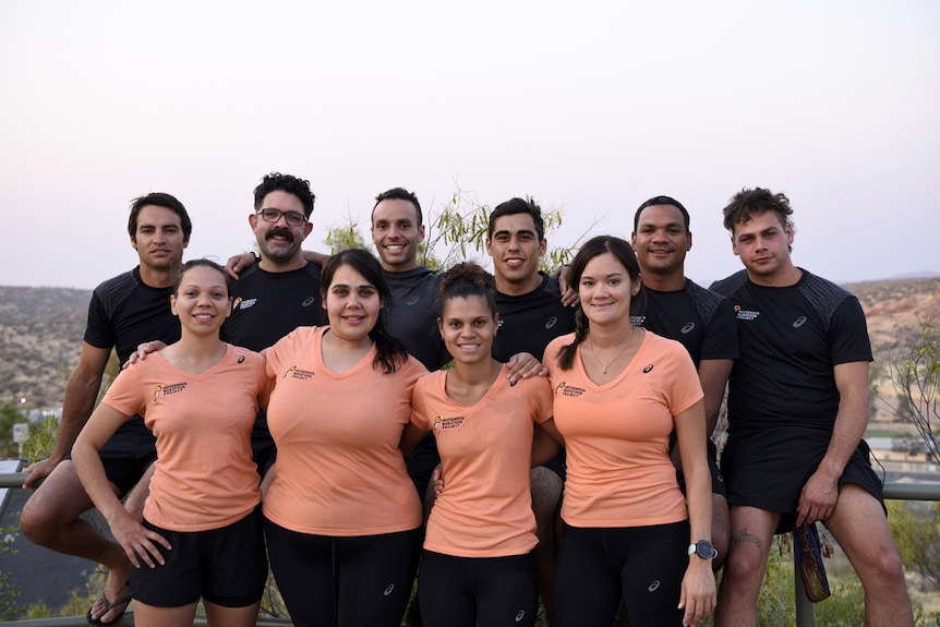 Indigenous Marathon Project squad stand arm in arm.