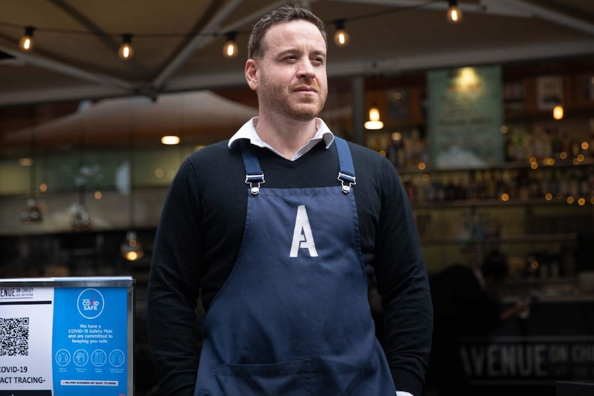 A man stands outside a cafe