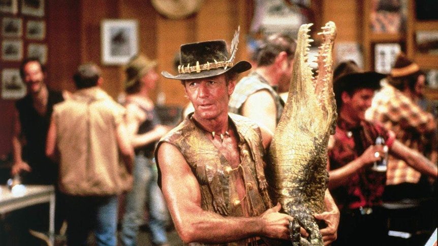 A still of Paul Hogan holding a crocodile from the 1986 film Crocodile Dundee