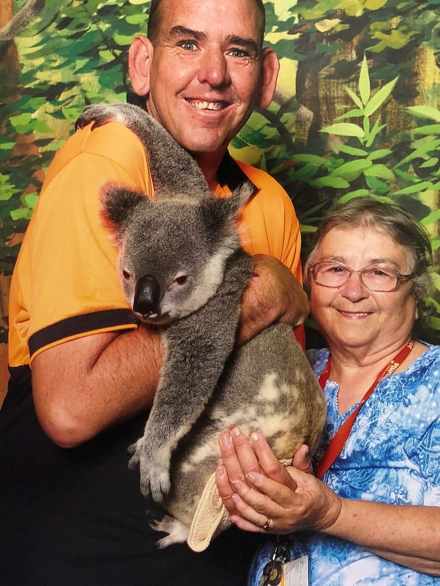 David Cuneo, holding a koala in his arms, stands next to his mother Wendy.