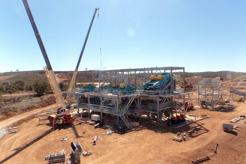 A wide shot of the Mt Marion lithium mine with a crane to the left of the mine structure.