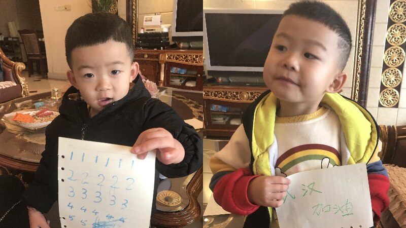 Composite image of two toddlers, holding sign saying Wuhan, add oil, meaning keep fighting.