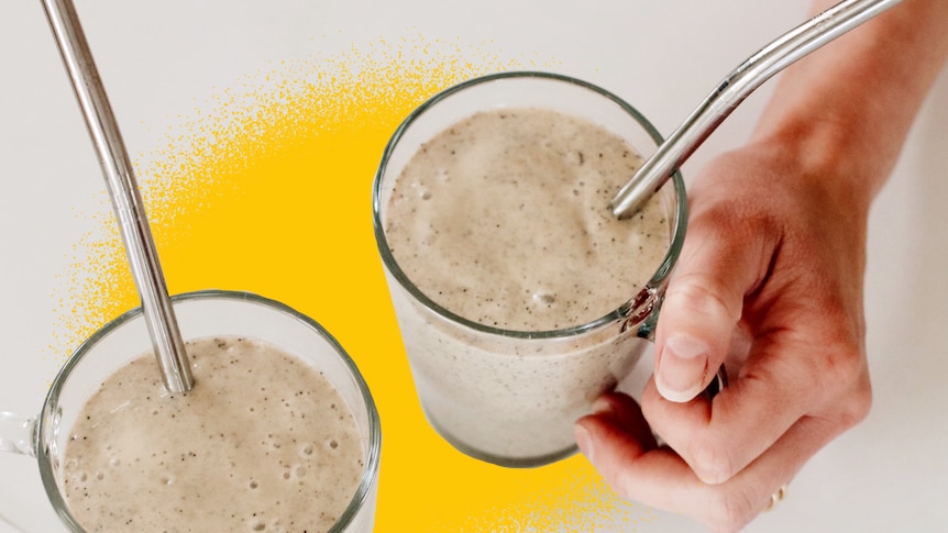 Two banana and passionfruit smoothies on a bench with stainless steel straws, a healthy breakfast recipe by Heidi Sze.