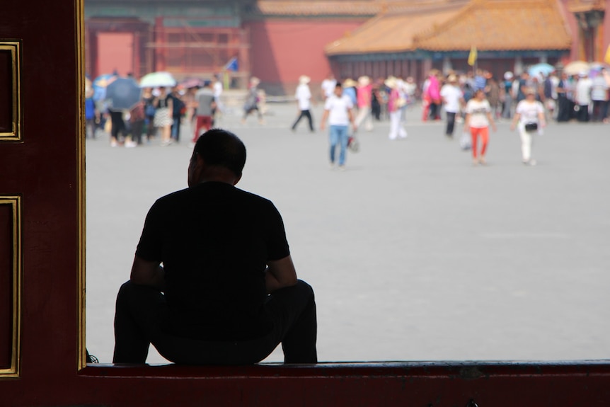 A man sitting in the forbidden city in china