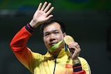 Vietnam's Hoang Xuan Vinh waves during the medal ceremony at the Rio Olympics.