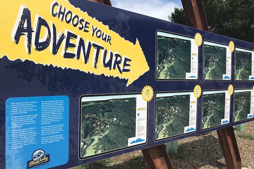 A sign saying "choose your adventure" at the Blue Derby mountain bike trails.