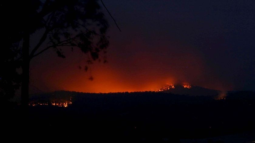 The glow from a bushfire at Healesville appears behind the hills