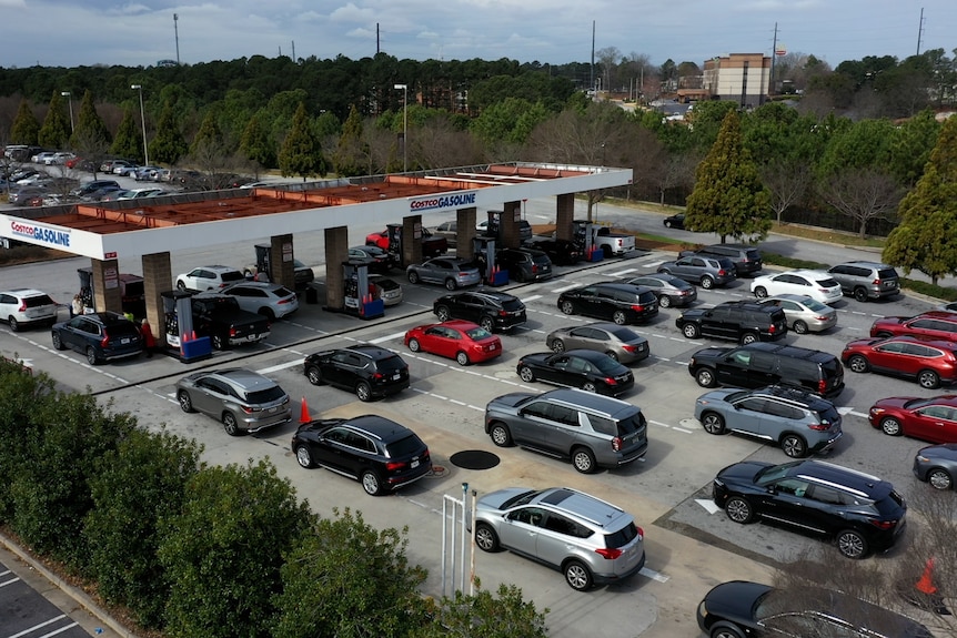 A drone shot of a petrol station filled with cars