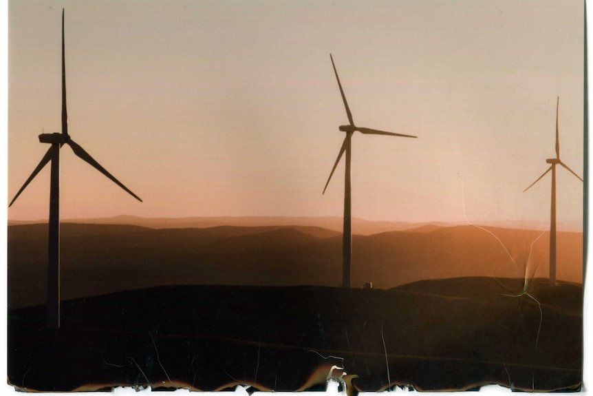 Wind turbines silhouetted at sunset.