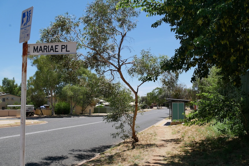Un cartel de la calle en una calle arbolada en Alice Springs