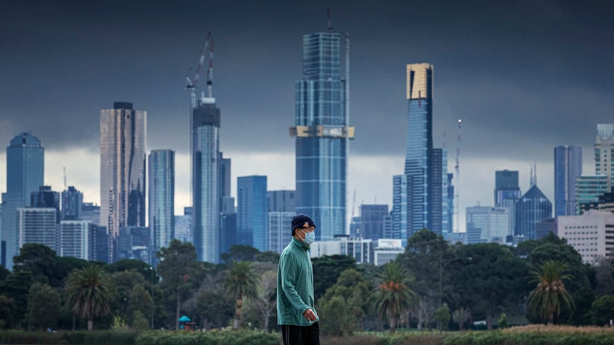 A general view at the Albert Park Lake in Melbourne as a single person wearing a mask walks past.