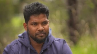 Thanush Selvarasa wearing a navy jacket with greenery in the background.