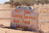 Humorous sign with writing on it advertising a pub. 