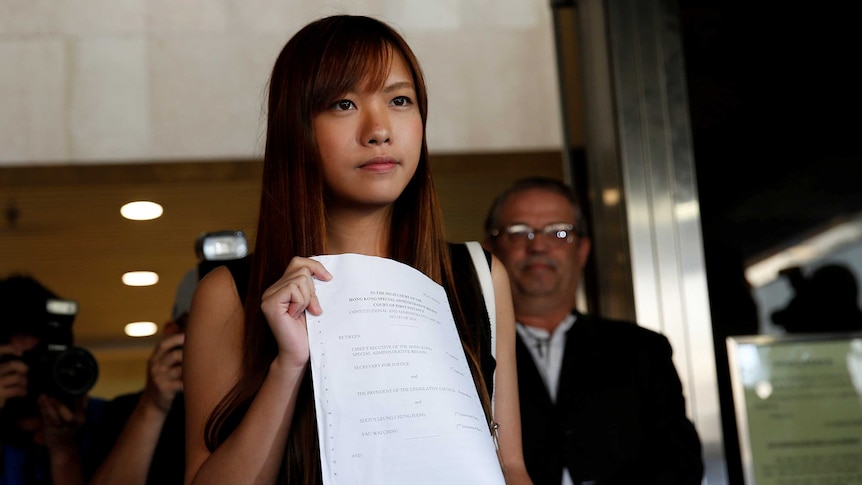 Barred politician Yau Wai-ching holds the judgment.