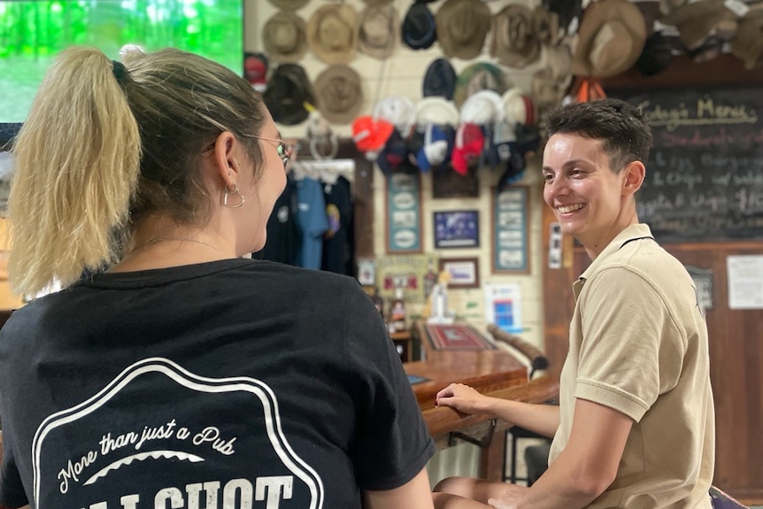 Two smiling women behind the bar in an outback pub.
