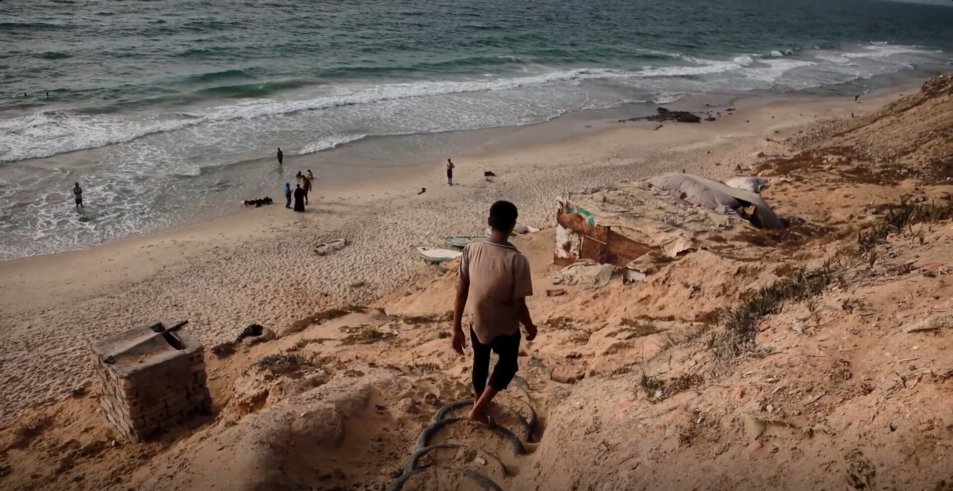 A boy walking down to a beach