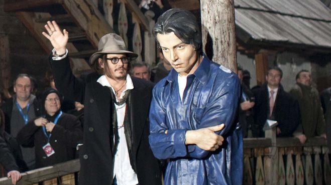 Johnny Depp stands next to a life-sized statue of himself