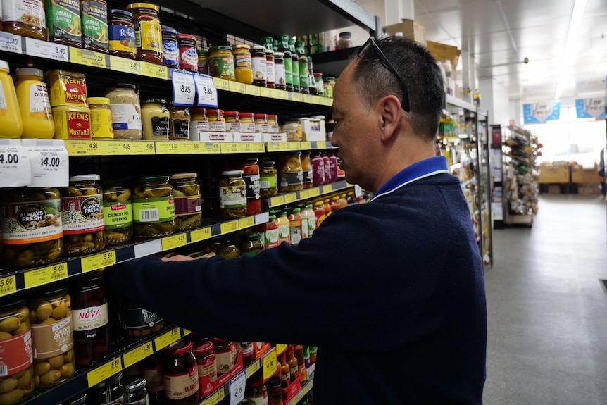 A man packs shelves in a supermarket.