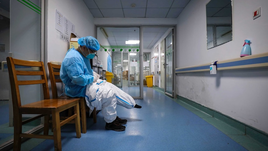 A doctor puts on a protective suit as he prepares to check on the patients.