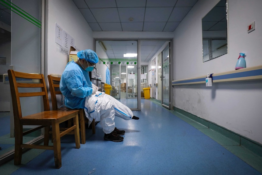 A doctor puts on a protective suit as he prepares to check on the patients.