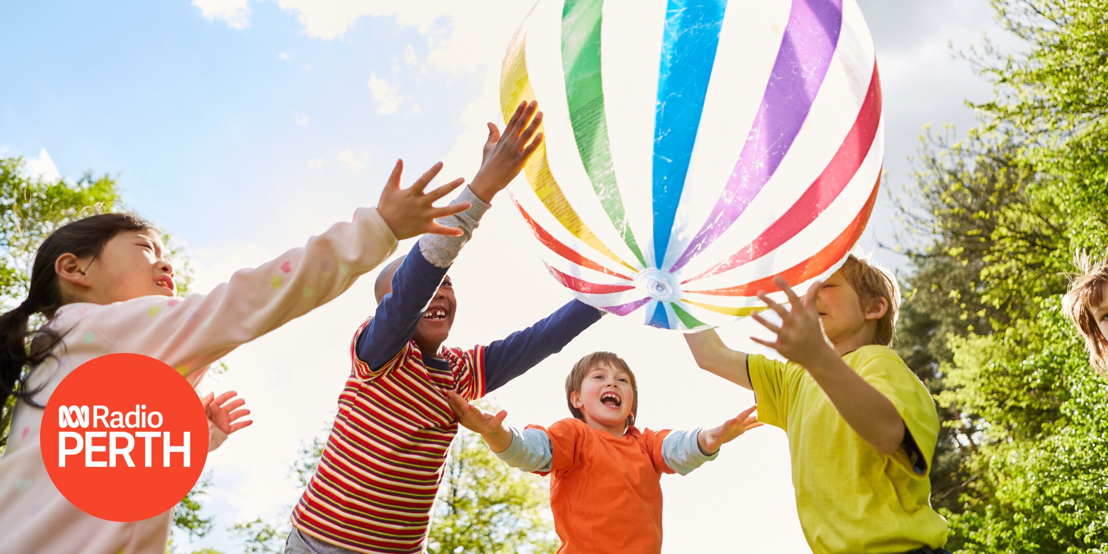 children putting hand in air to catch colourful stripey ball. ABC Radio Perth logo