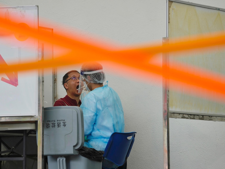 A resident gets tested for the coronavirus in Hong Kong, Sunday, Jan. 23, 2022. 