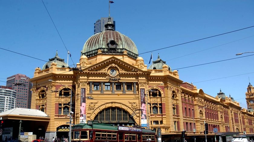 A W-class tram passes by the front of Flinders Street train station in Melbourne