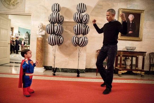 Barack Obama flexes biceps with young Superman Walker Earnest in the White House.