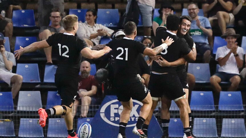 New Zealand All Blacks players run to Will Jordan (right) to hug him after a try against Argentina.