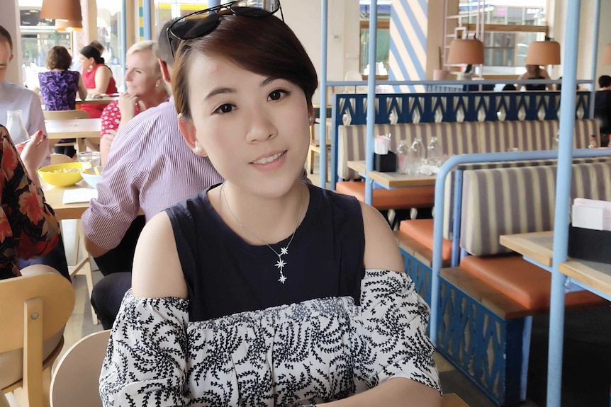 A woman sits in a restaurant in Australia.